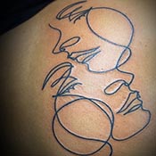 abstract lines of faces tattoo on shoulder